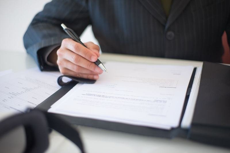 Firma dei documenti di una pratica automobilistica sulla scrivania dell'agenzia